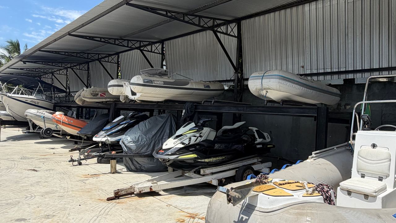 Área coberta com jet skis e botes infláveis em suportes